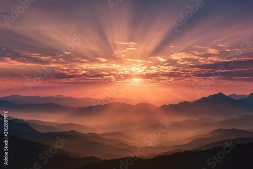 Breathtaking Sunrise Over Mountains with Colorful Sky and Radiant Sunlight Spreading Across the Horizon