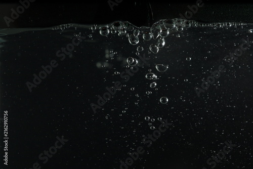 Foto Dark underwater bubbles rising through black water, captured in a dramatic macro view with transparent air spheres, subtle reflections, and flowing motion