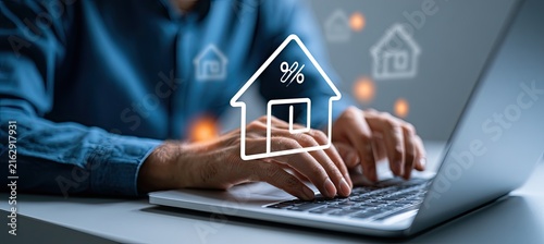 Person typing on laptop with house and percentage icon overlay, symbolizing real estate or mortgage online.