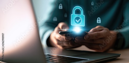 Digital Security Concept - Person Using Smartphone with Glowing Padlock Icon and Laptop.
