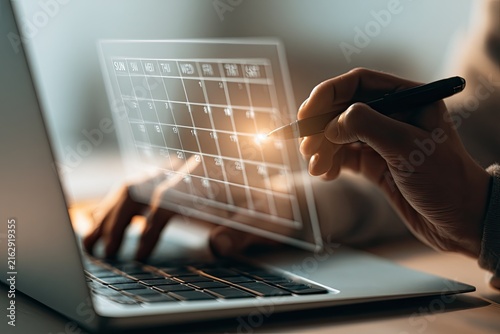 Digital Calendar Interface on Laptop Screen with Hand Using Stylus.