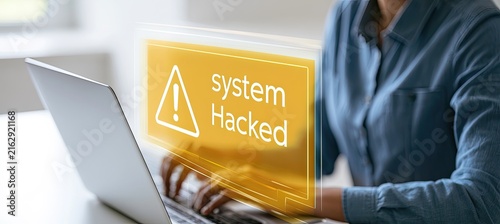 Person looking at laptop screen with a warning about system hacked.