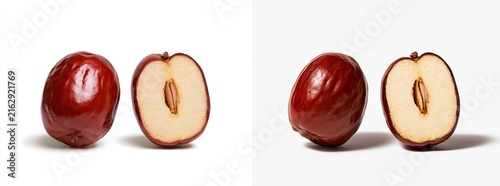 Two whole and two halved fresh red jujube fruits on a white background.