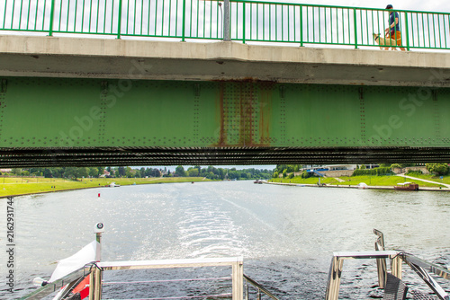 Konstfotografi A green-and-gray bridge seen from a boat passing beneath it