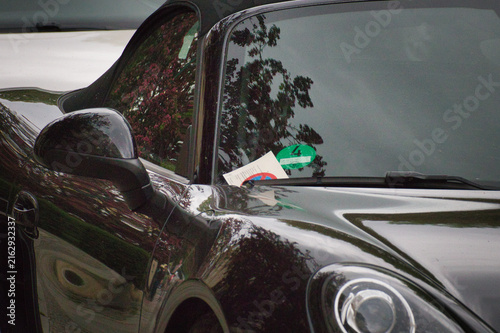 Nahaufnahme von einem Strafzettel hinter dem Scheibenwischer eines Luxusautos der Marke Porsche geparkt im Stadtgebiet – Landkreis Leipzig, Sachsen, Deutschland