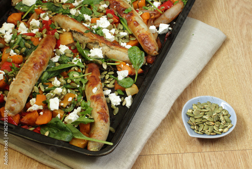 Sheet pan roasted sausages with pumpkin, spinach, feta cheese, and pumpkin seeds