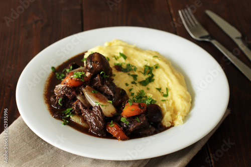 Beef bourguignon stew with mushrooms and carrots served with creamy mashed potatoes