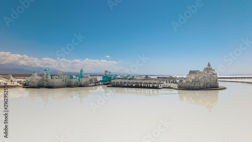 Fotografie Salt Works Structures on Calm Lake Under Clear Blue Sky