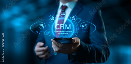 Businessman holding smartphone with CRM Customer Relationship Management icons on screen
