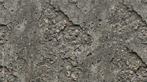 Weathered concrete wall with cracks and small stones, rugged texture background