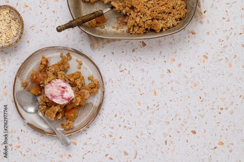 Fotografie Apple oat crumble with ice cream on terrazzo table