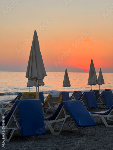 Konstfotografi Beach with sun loungers and umbrellas at sunset
