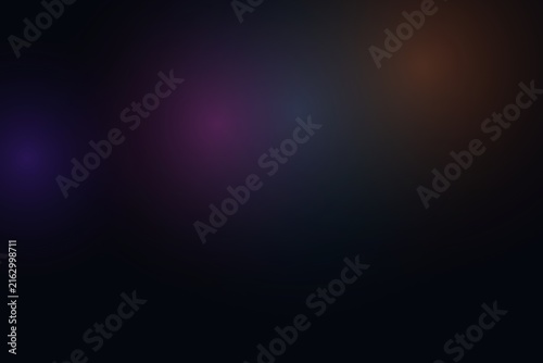 Abstract dark background featuring soft gradient light spots and flares.
