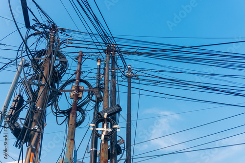 Quadro su tela Tangled wires stretch skyward against blue