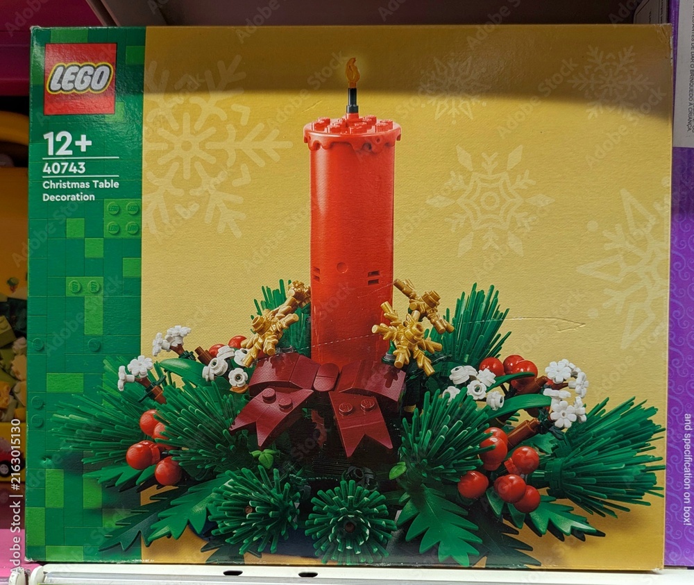 Fototapeta premium Caja de construcción de Lego con decoración para una mesa de Navidad, con una vela, bayas y hojas de plantas de plástico en juguetería Toy Planet de Madrid, España, 6 de junio de 2026