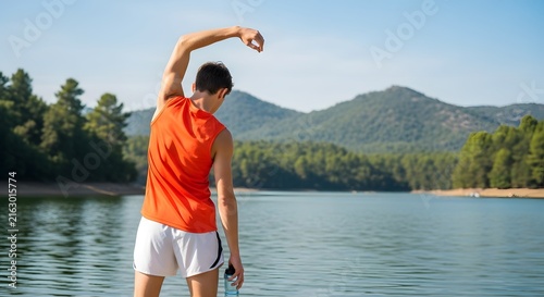 Fit man stretching arms outdoors by a lake for workout warm up and healthy lifestyle