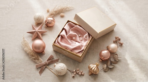 Decorative gift box lined with pink silk fabric, surrounded by ornaments and dried flowers