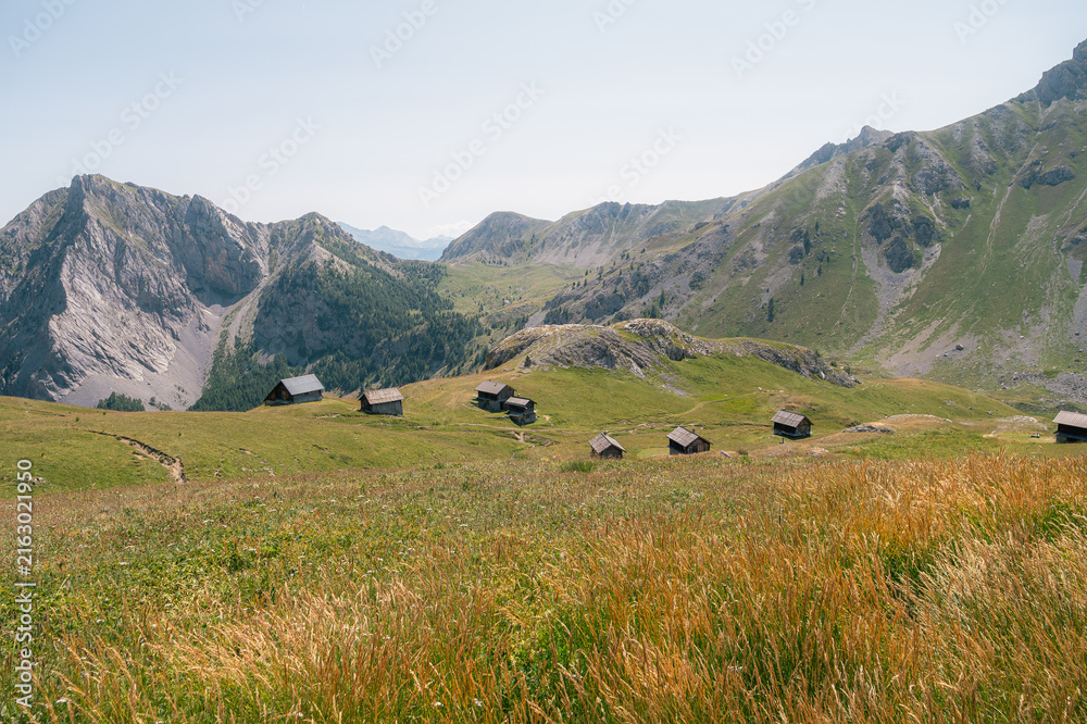 Naklejka premium Alpage de montagne avec chalets dispersés dans les Alpes françaises