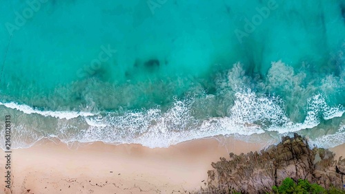 A concept drone is relaxing on a pristine, tropical white sand beach, Freedom Beach, Phuket, Thailand, on a sunny day. It's a hidden tropical beach, deserted during the low season.