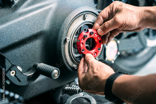 Mechanic installing red anodized CNC aluminum clutch retainer plate on motorcycle primary engine