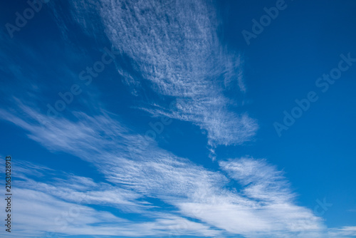 Foto Wispy cirrus and textured cirrocumulus clouds spreading across a vibrant blue sky on a bright sunny day