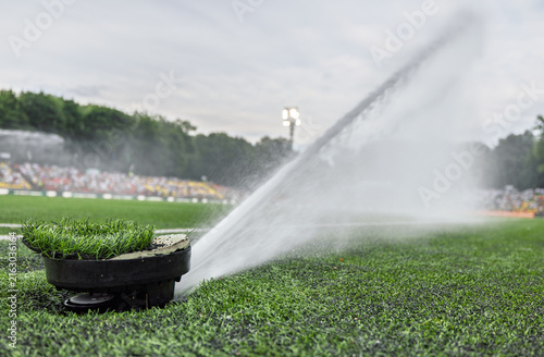Stadium Sprinkler Watering Grass On Sports Field During Groundskeeping And Irrigation Maintenance