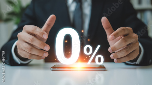 Businessman Presenting Zero Percent Interest Rate with Glowing Numbers on a Smartphone Keywords: business, finance, zero percent, interest rate, loan, mortgage, offer