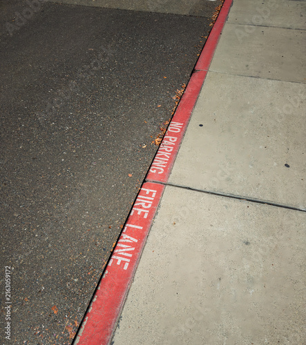 Red painted curb marking no parking fire lane along street