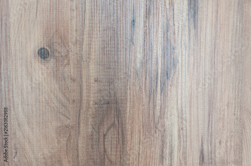 Close-up texture of natural brown wooden board with fibers and a knot, abstract timber surface background