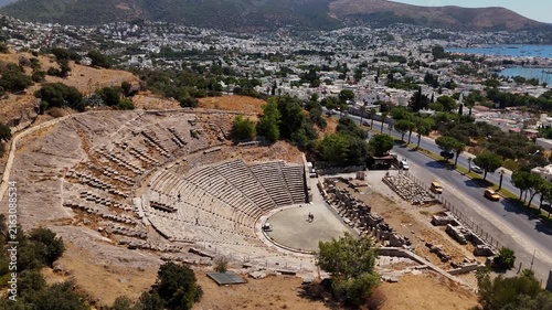 Aerial drone view of the Ancient Theater of Halicarnassus in Bodrum, Turkey, featuring the well-preserved Greek amphitheater overlooking the city.