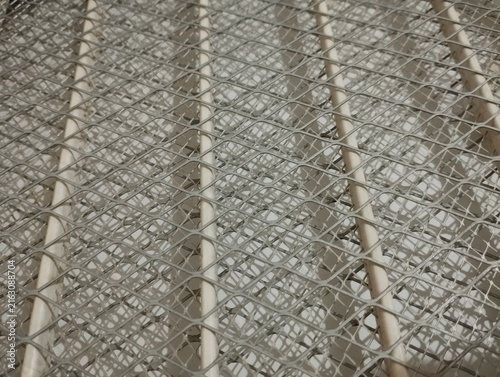 Konstfotografi Close-up view of a white mosquito repellent coil protected by a metal wire mesh, creating an intricate geometric pattern