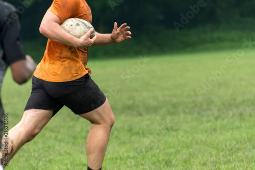 Canvas Print Running with holding rugby ball on grass play ground