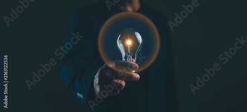 Foto A hand holds a glowing light bulb in the dark, symbolizing innovation and bright ideas