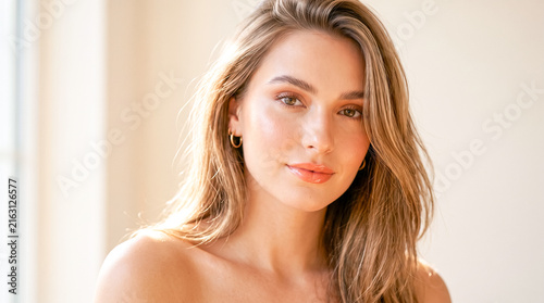 Beautiful woman with long hair smiling naturally in soft natural light