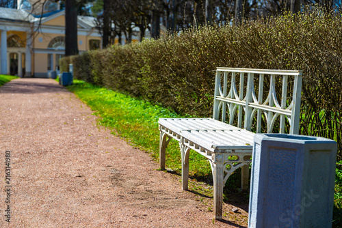 White bench sits beside gravel path