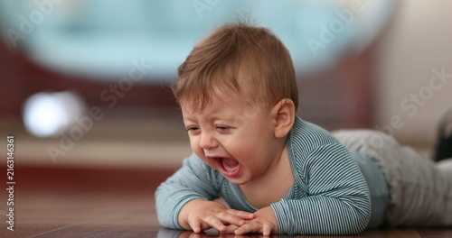 Fotografie Unhappy Baby boy infant toddler complaining crying out