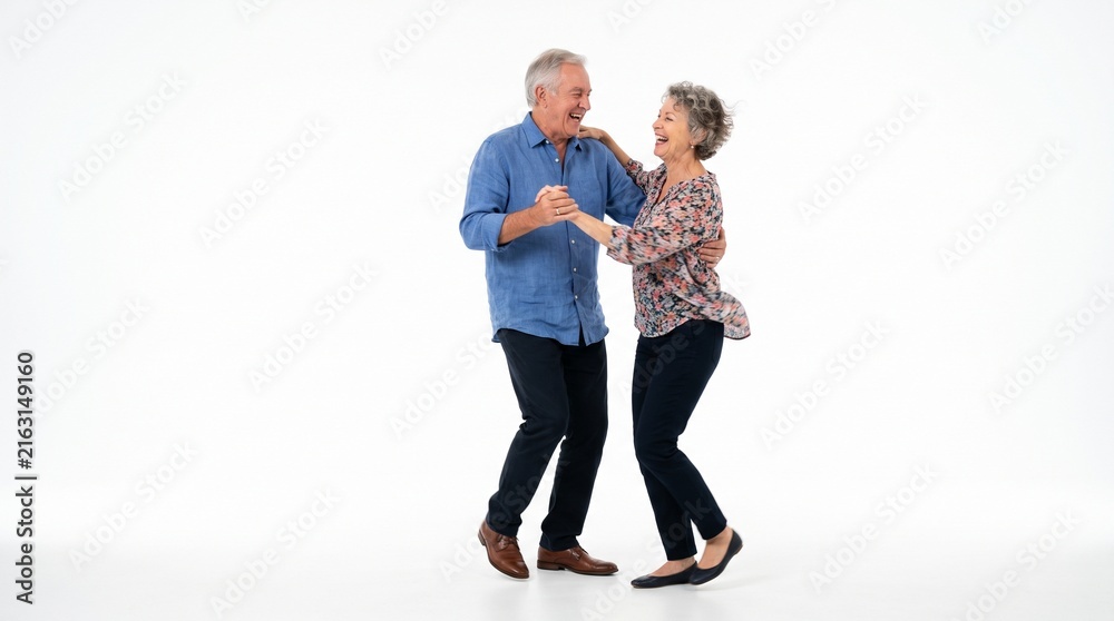 Fototapeta premium Joyful elderly couple dancing together with laughter and smiles on a white background