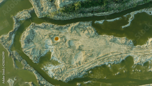 Aerial view of the Chibayish marshes featuring winding water channels cutting through sandy terrain and lush vegetation in Chibayish, Dhi Qar Governorate, Iraq.