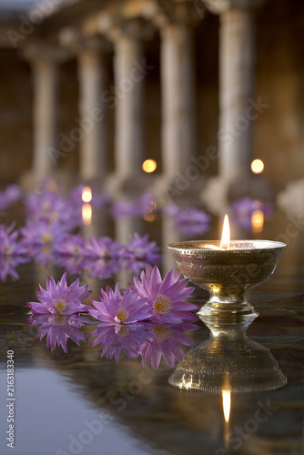 Lit Oil Lamp Floating with Pink Lotus Flowers on Water in Ancient Temple