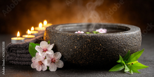 Steaming Spa Bowl with Cherry Blossoms and Candles for Relaxation