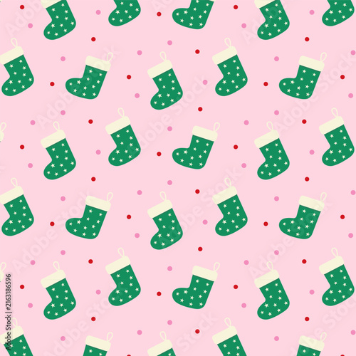 Cute Christmas seamless pattern.Green stocking and polka dot repeat pattern isolated on pastel pink background.