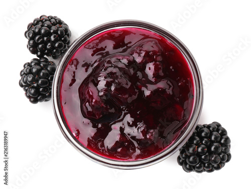 Delicious blackberry jam in glass bowl and fresh berries isolated on white, top view