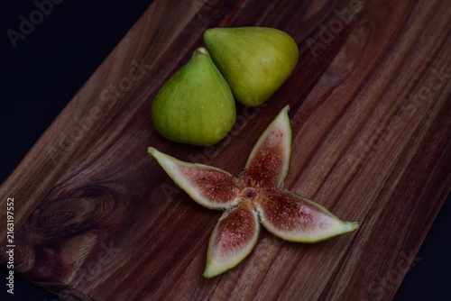 Fresh figs and a sliced fig on a wooden board
