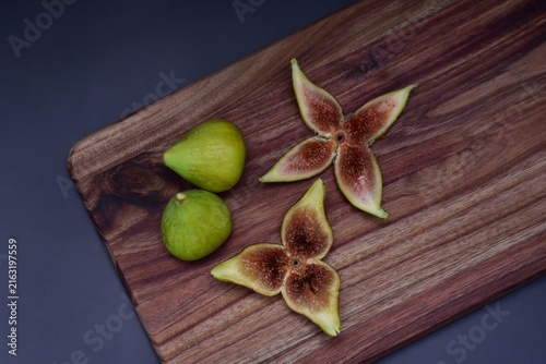 Fresh figs whole and sliced on a wooden serving board