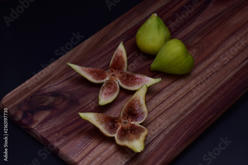 Fresh green figs whole and sliced on a serving board