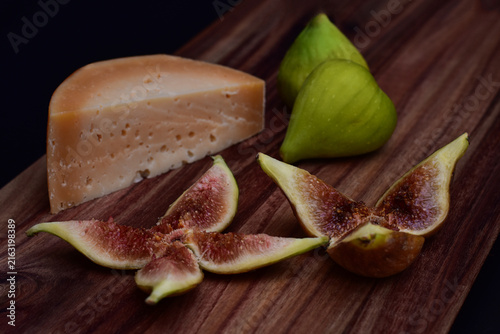 Cheese and figs served on a wooden board