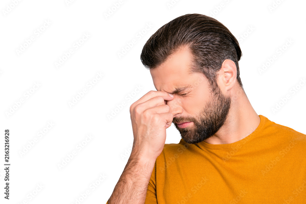 Fototapeta premium Close up portrait of stressed sick sad upset bearded guy with stylish haircut touching nose-bridge isolated on gray background copy-space