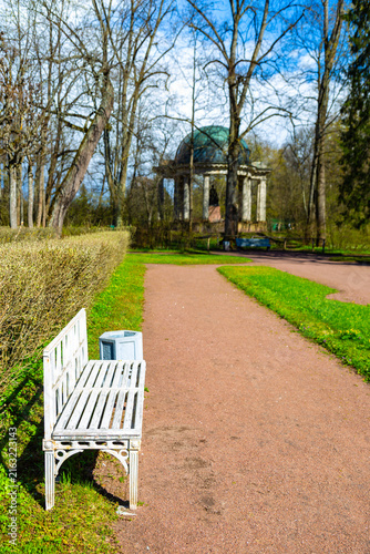 White bench invites quiet moments in park