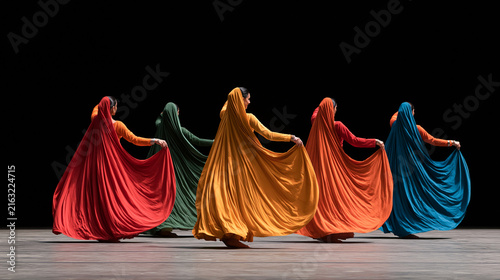 Group of professional Indian dancers performing energetic choreography in colorful traditional clothing, flowing fabrics, expressive movement, cultural celebration, Indian dance,
