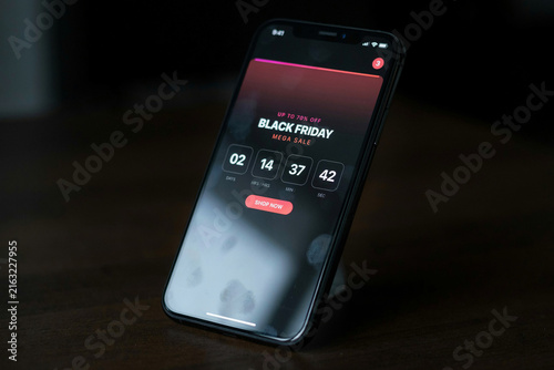 Black Friday mega sale app on smartphone screen, digital countdown timer for online shopping, mobile e-commerce promotion on dark background